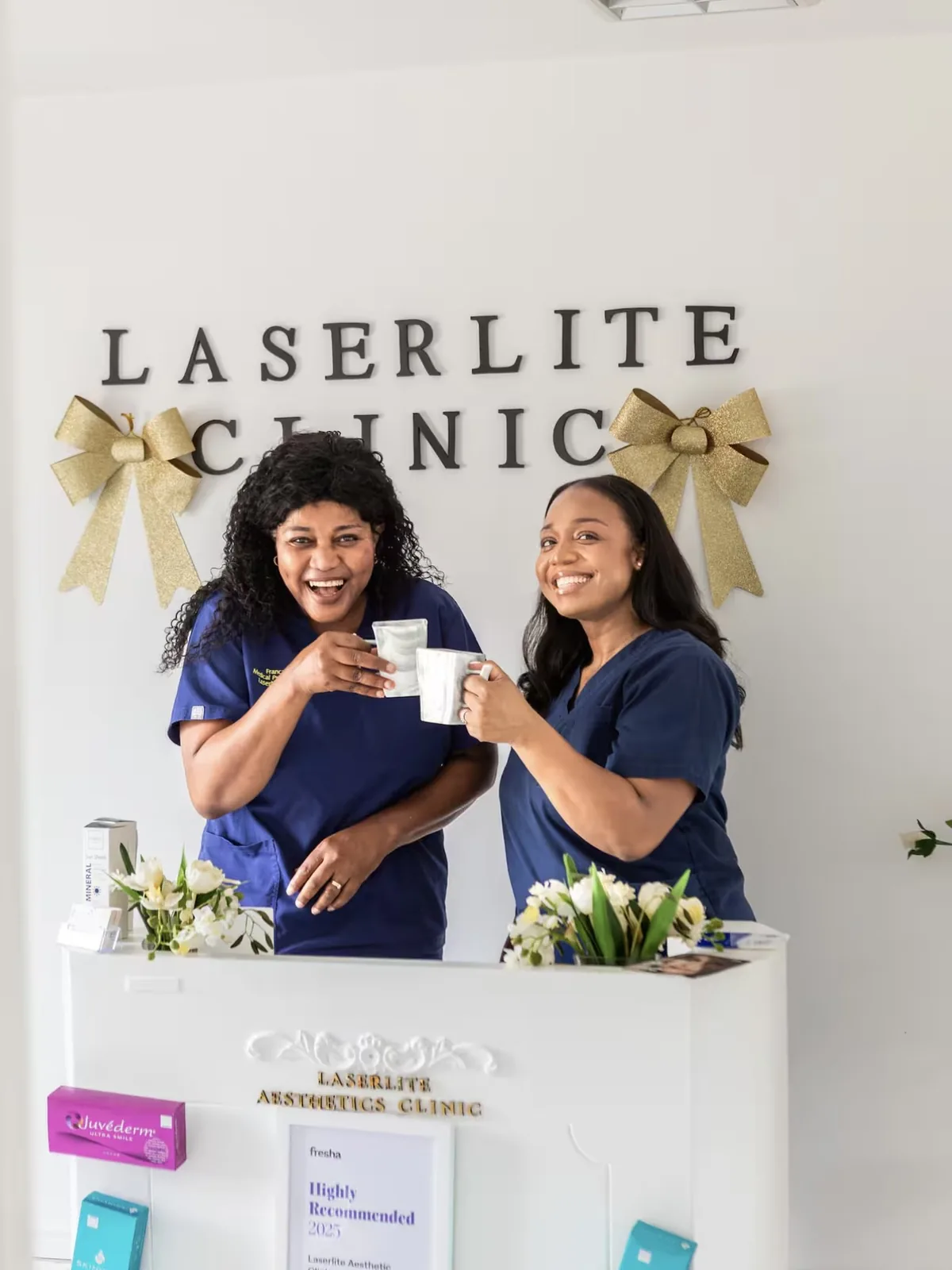 The Laserlite team at the reception desk under the clinic lettering The Laserlite team at the reception desk under the clinic lettering